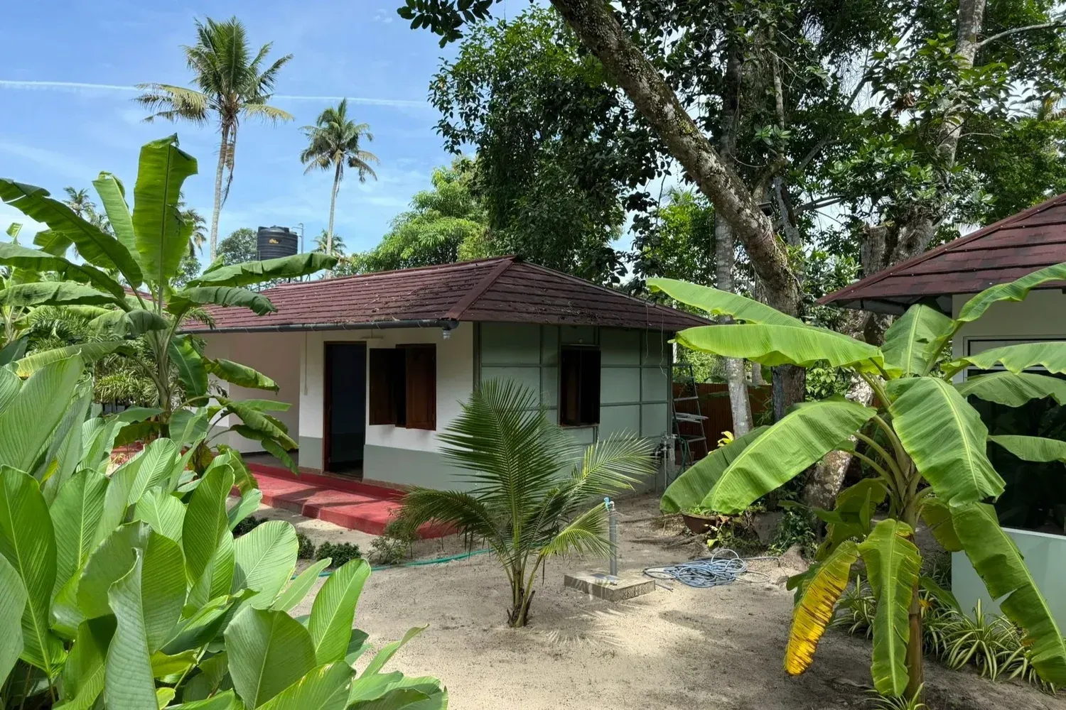 Cottages beside a garden waterway at Ayurprana Heritage in Marari