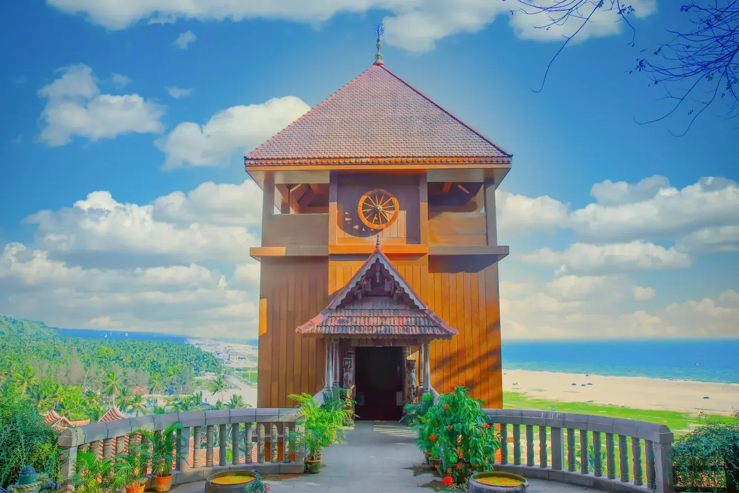Wooden clock tower in Kerala palace style at AyurSoma, with the sea behind