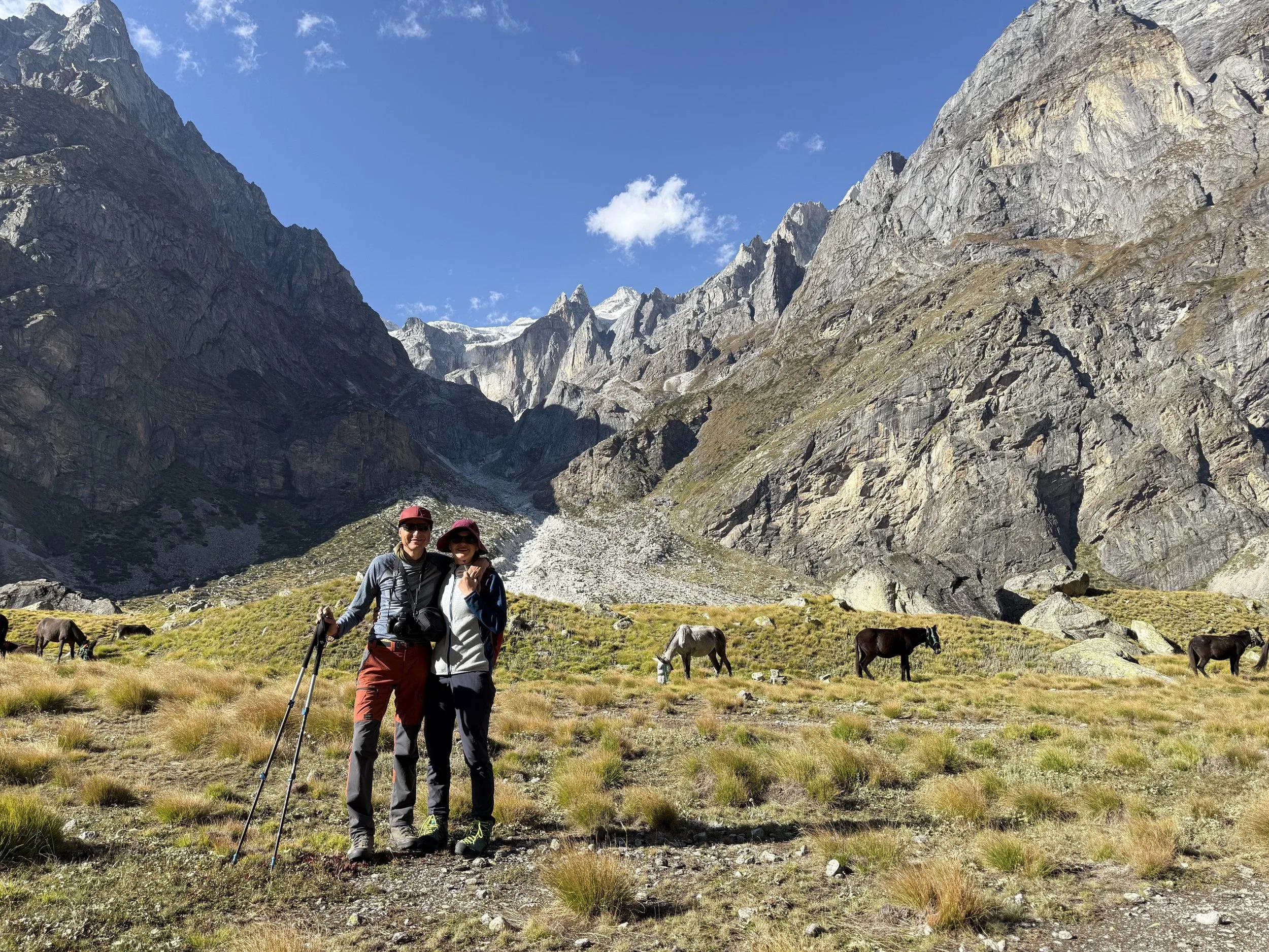 Martin and Lenka on a trek in the Himalayas, with mules grazing behind them
