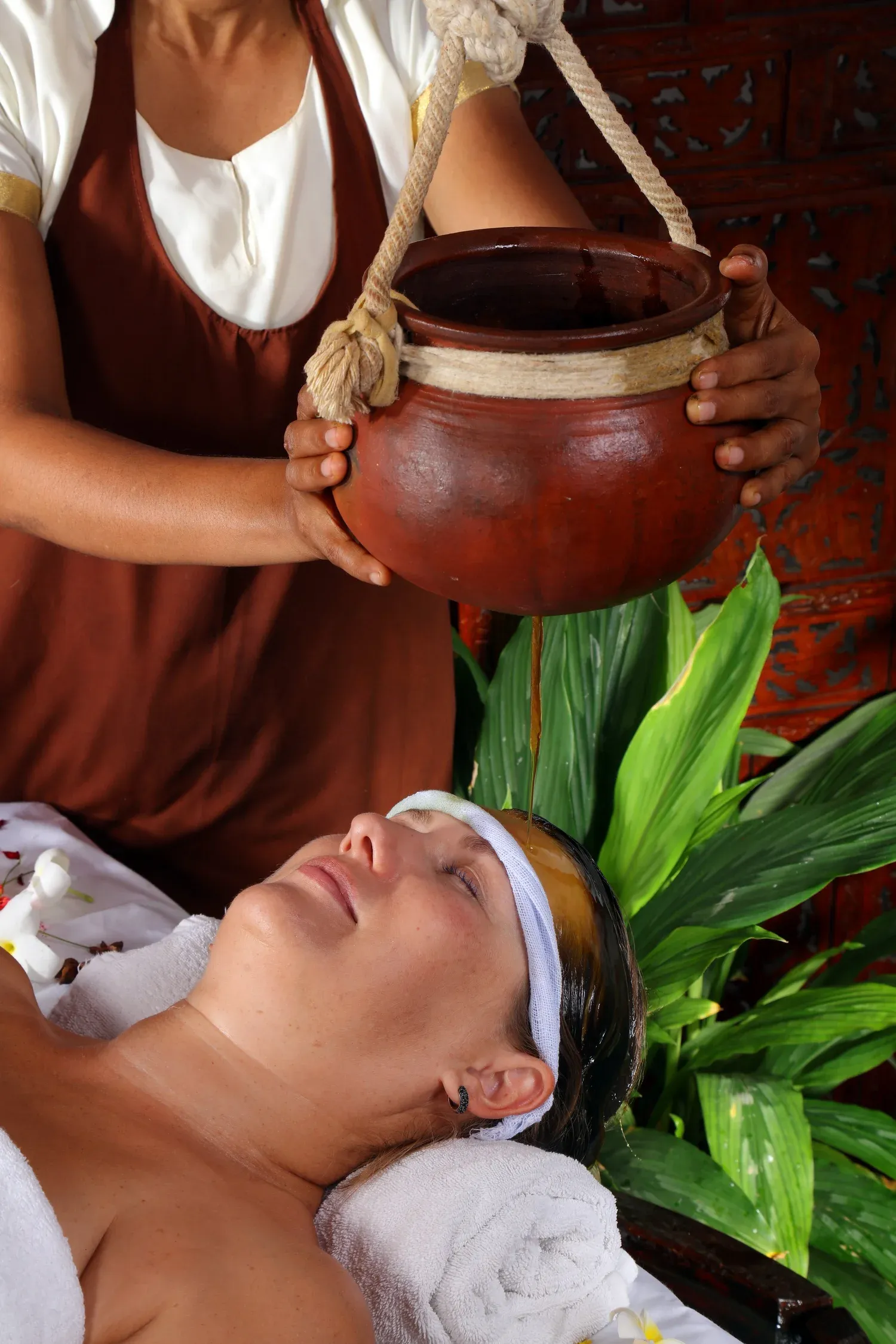 Ayurvedic oil treatment on a wooden table